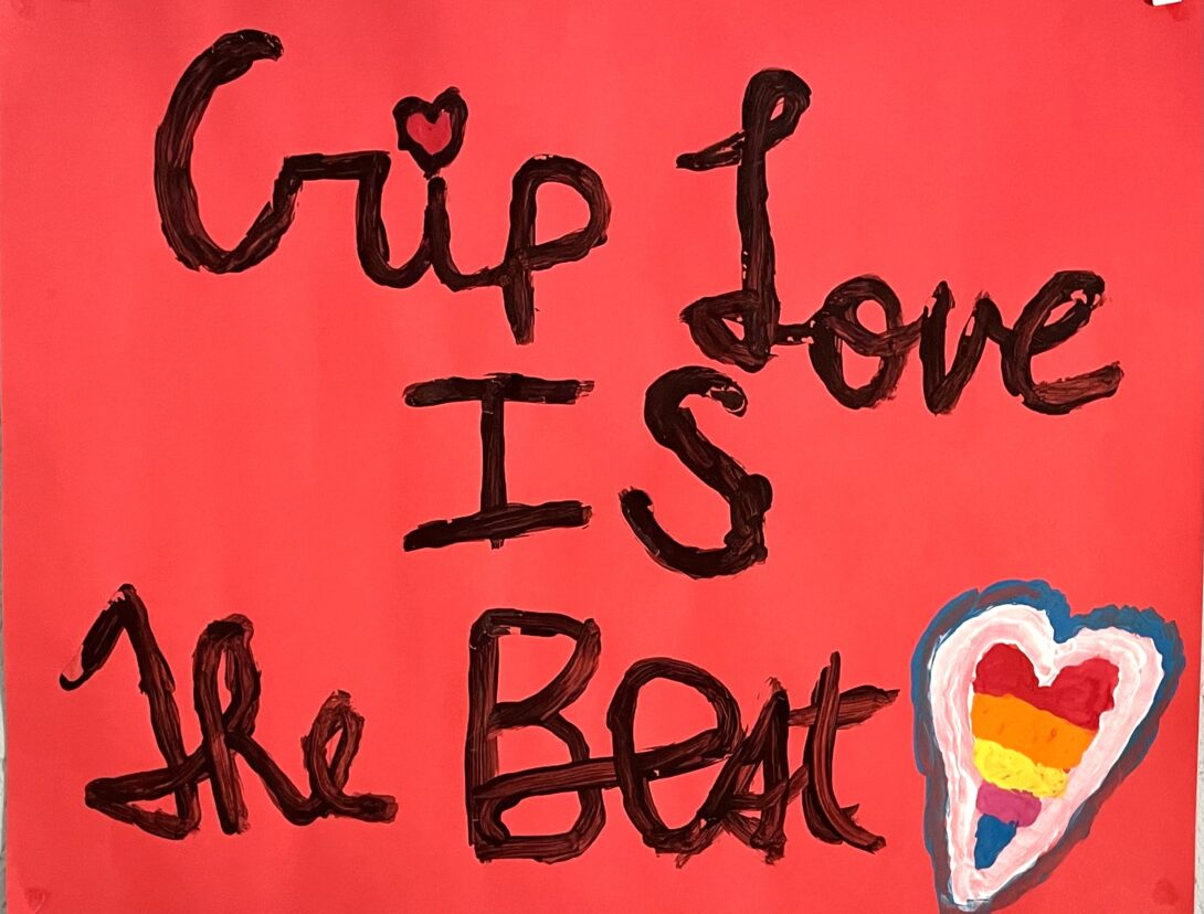 A red poster with the words “Crip love is the Best” written in cursive with black paint with a heart over the letter I in Crip. There is a heart with the LGBTQ pride colors in the bottom right corner.