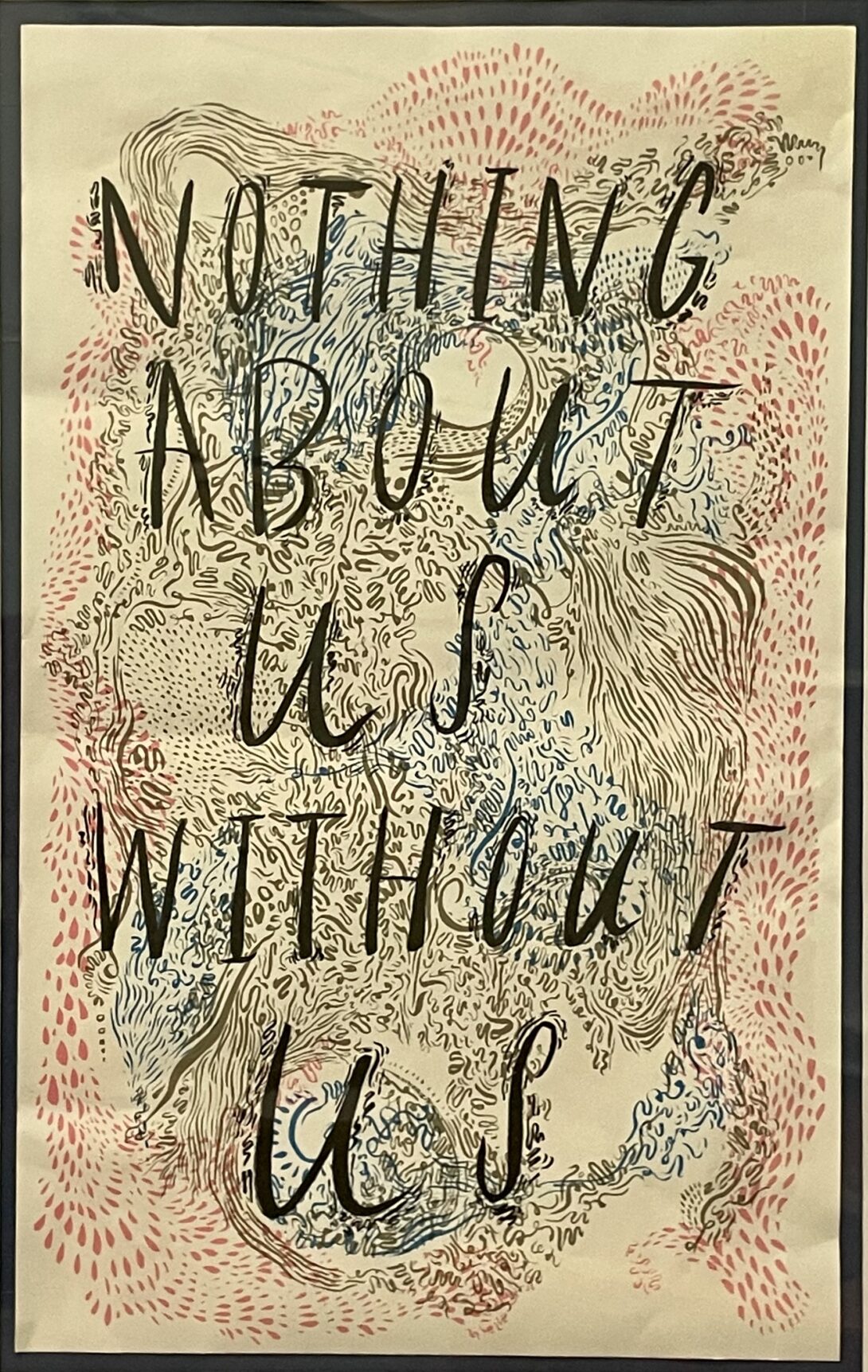 A black rectangular frame with a thick white border around the artwork in the center. The artwork has a white background with a swirl of pink, dark gray, and blue of differing patterns. The pink pattern is petals and the dark gray and blue are wavy lines. On top of this is the text which reads “Nothing About us Without us”